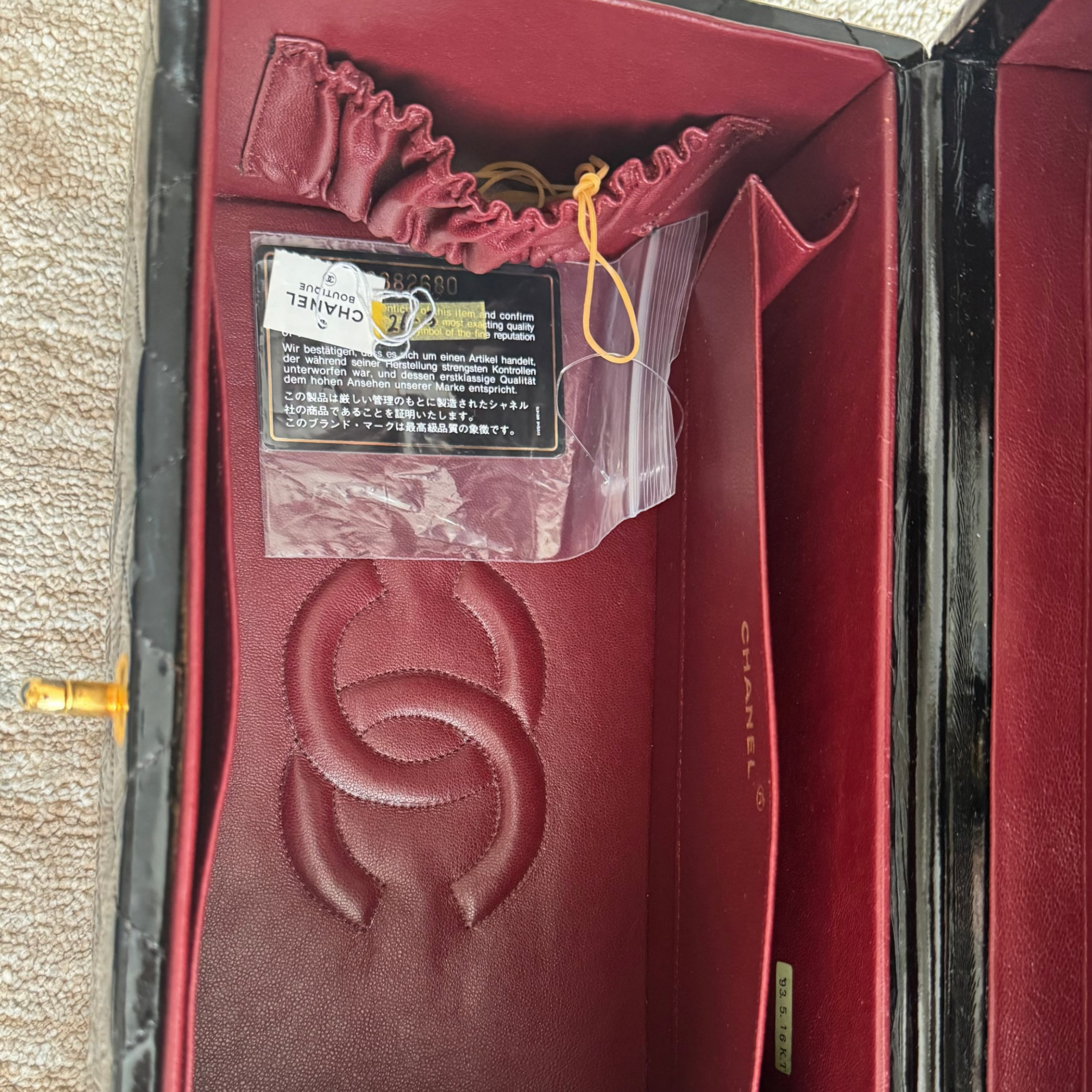 Red Chanel wallet inside an open box on a textured surface