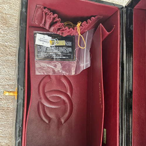 Red Chanel wallet inside an open box on a textured surface